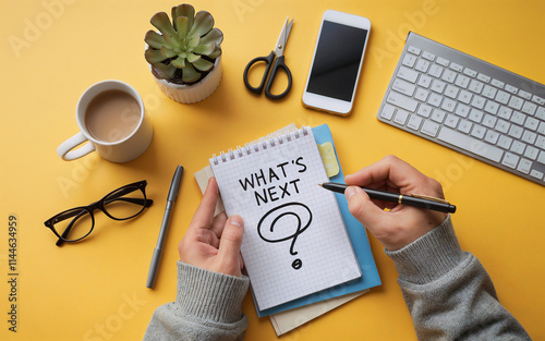 What's next? text written on small paper on a yellow background with office table items.