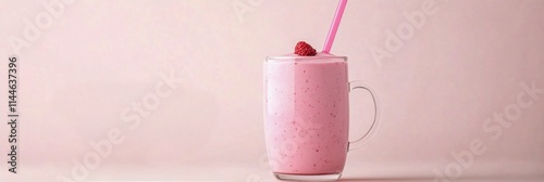 Delicious pink smoothie topped with fresh raspberries served in a clear glass...