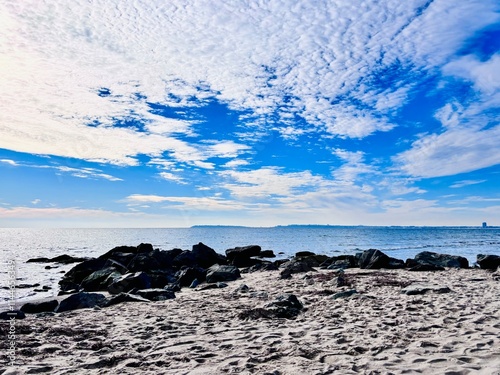 rocks on the beach and cloudy sky over the sea