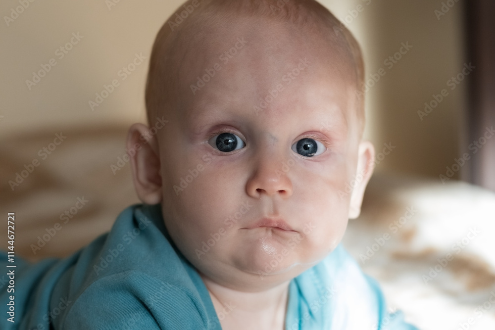 Close-up portrait of a baby, newborn boy, 9 months old, with big blue eyes Close-up portrait of a baby, newborn boy, 9 months old, with big blue eyes