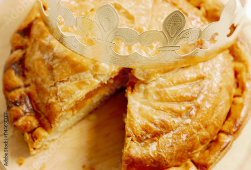 One cut royal galette with a crown on the table. photo