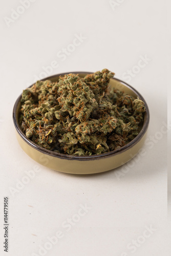 in a bowl dry flowers of medical cannabis. On a light background photo