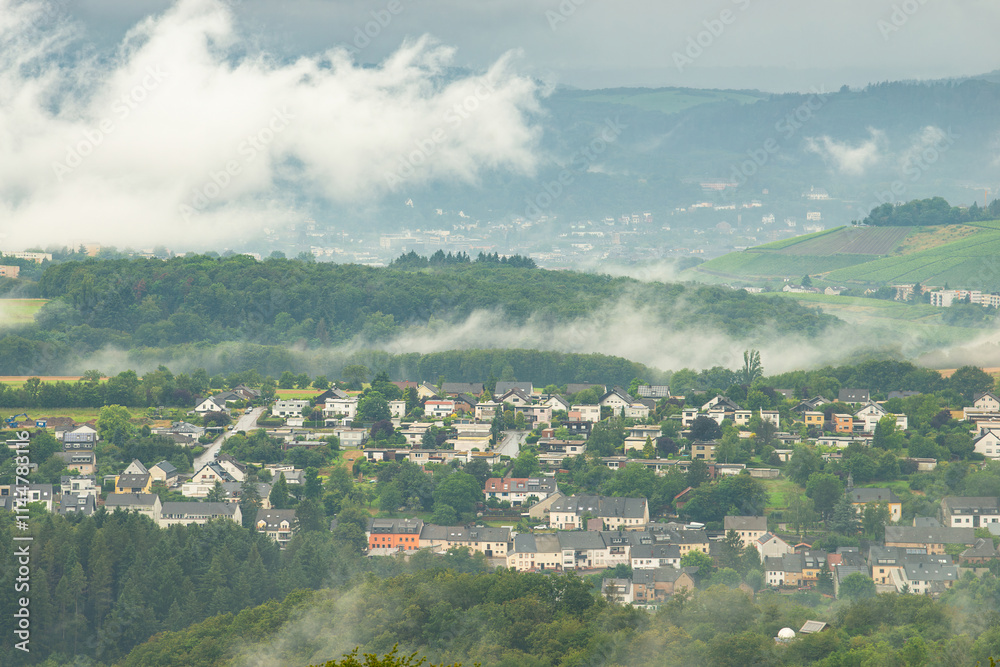 Fototapeta premium Dark storm clouds over the city of Trier in Germany, landscape with vineyards, agriculture field and forest, rainy weather in summer