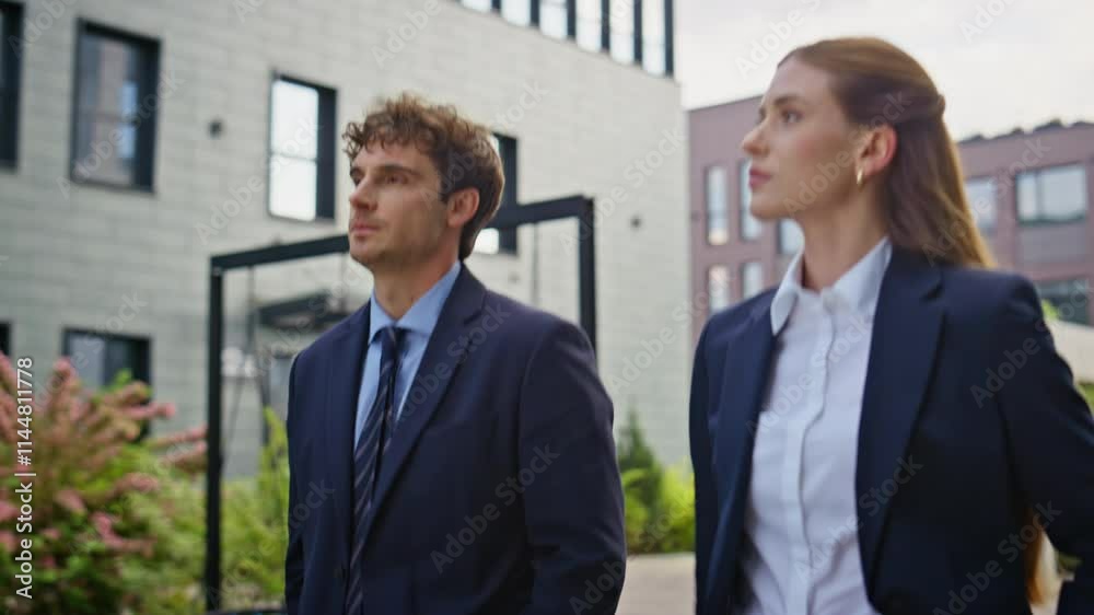 Serious professionals walking city in elegant suits closeup. Corporate partners Serious professionals walking city in elegant suits closeup. Corporate partners