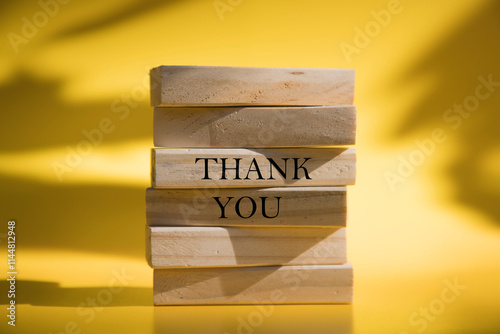 Thank you symbol. Wooden blocks with words Thank you. Beautiful yellow background.Natural light. Business and Thank you concept. Copy space.