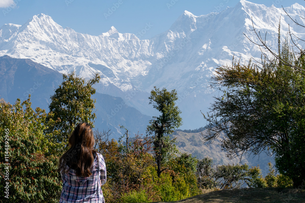 A lone traveler gazes at the towering snow draped Himalayan peaks, soaking in the awe-inspiring beauty of nature and its tranquil embrace. Himalayan range seen from Deoria Tal in Uttarakhand, India. A lone traveler gazes at the towering snow draped Himalayan peaks, soaking in the awe-inspiring beauty of nature and its tranquil embrace. Himalayan range seen from Deoria Tal in Uttarakhand, India.