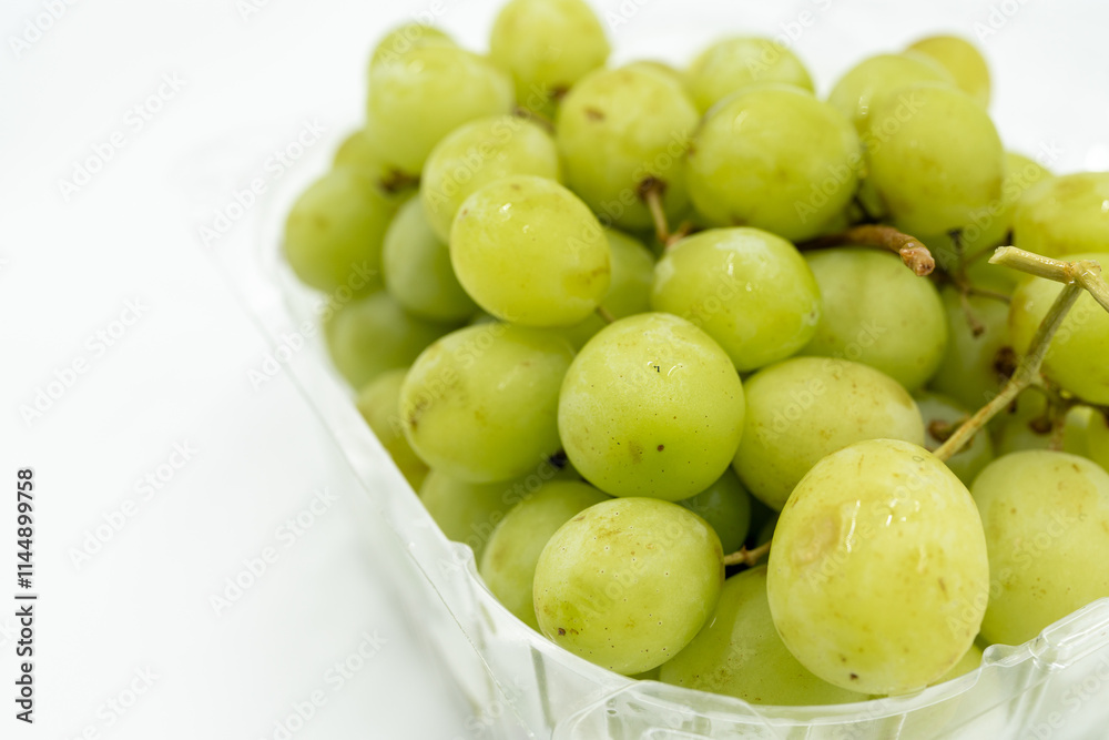 Fresh green grapes in clear plastic container, juicy and healthy Fresh green grapes in clear plastic container, juicy and healthy