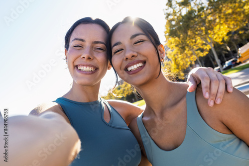 Ttwo beautiful friends with sporty clothes taking a selfie with smartphone in the city photo