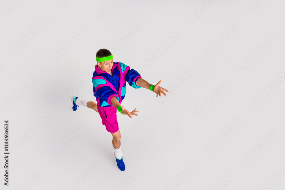Fototapeta premium Energetic young man in retro sportswear performing a dynamic exercise on a white background