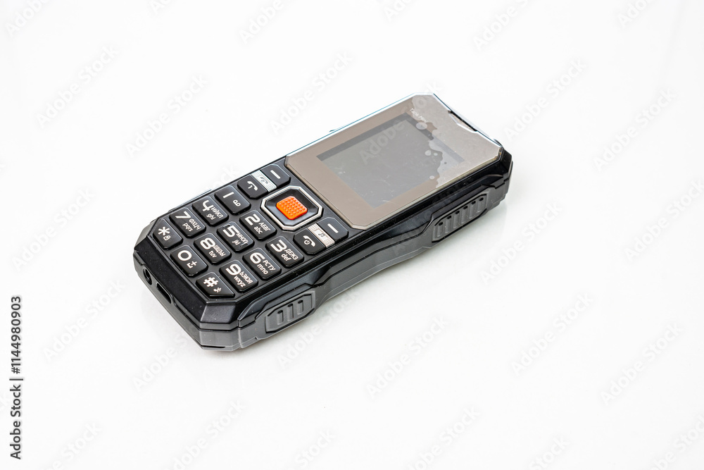 Small push-button cell phone on a white background. Obsolete model. Space for inscription, space for copying Small push-button cell phone on a white background. Obsolete model. Space for inscription, space for copying