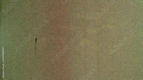 Looped noisy, grainy background beige film archive. Aged backdrop natural orange with scratches. Seamless loop old archival video. Dirty grunge overlay noise in retro abstract video. Vintage texture