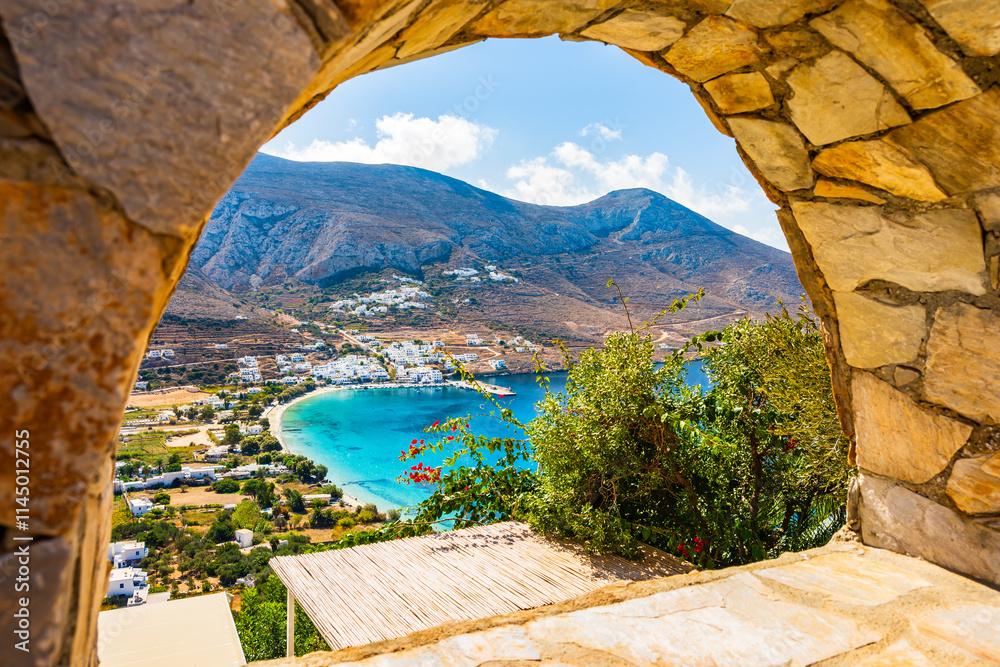 View of Aigiali sea bay with mountains framed by stone arch, Amorgos island, Cyclades, Greece
