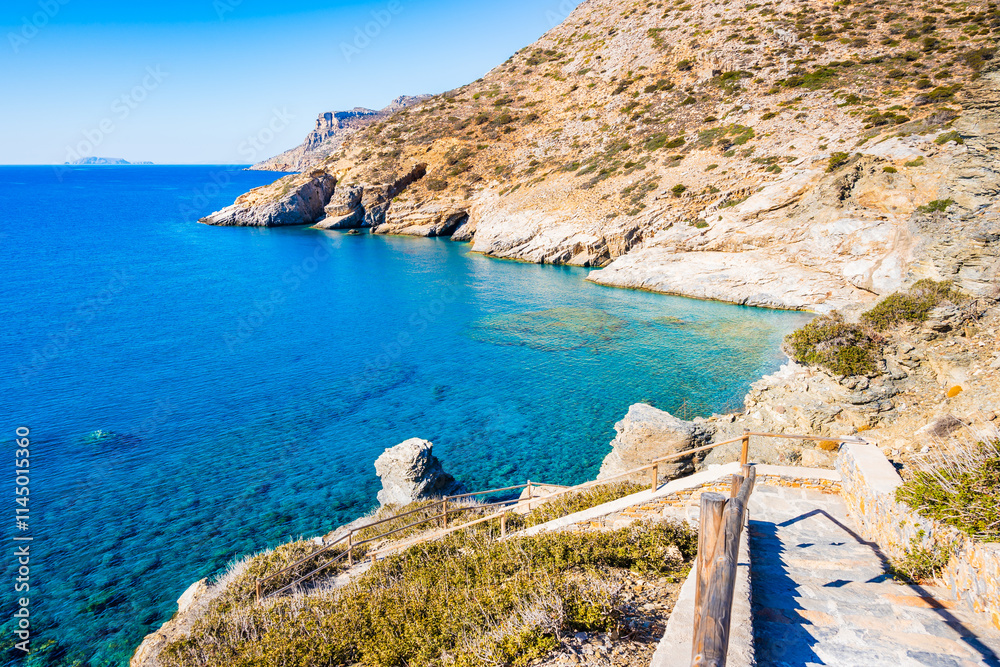Walking path with steps to Mouros bay and beach with high cliffs and blue sea, Amorgos island, Cyclades, Greece