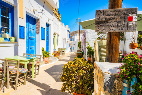 Fototapeta Naklejka Na Ścianę i Meble -  Sign with time directions for tourists doing trekking trails in narrow street of Lagada village, Amorgos island, Cyclades, Greece