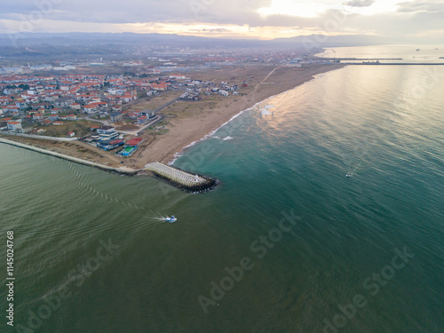 Fototapeta Naklejka Na Ścianę i Meble -  Karasu Sakarya Adapazari Turkiye Drone Shot Turkey Aerial View of Coastal Town and Harbor at Sunset. A breathtaking aerial shot of a coastal town nestled beside a harbor at sunset.
