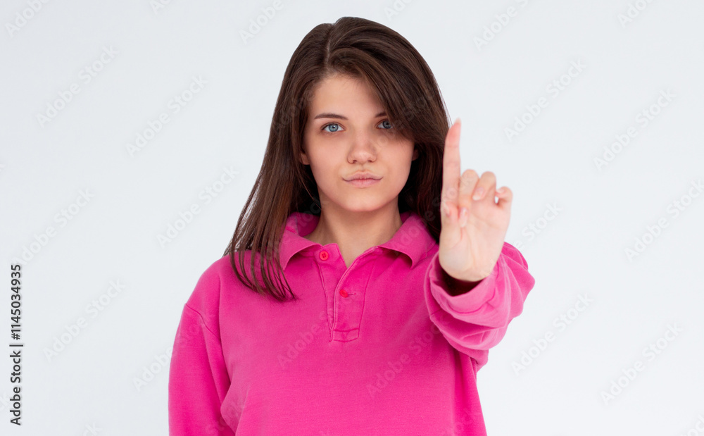 Portrait of young woman making stop sign with finger in front of the camera. Portrait of young woman making stop sign with finger in front of the camera.