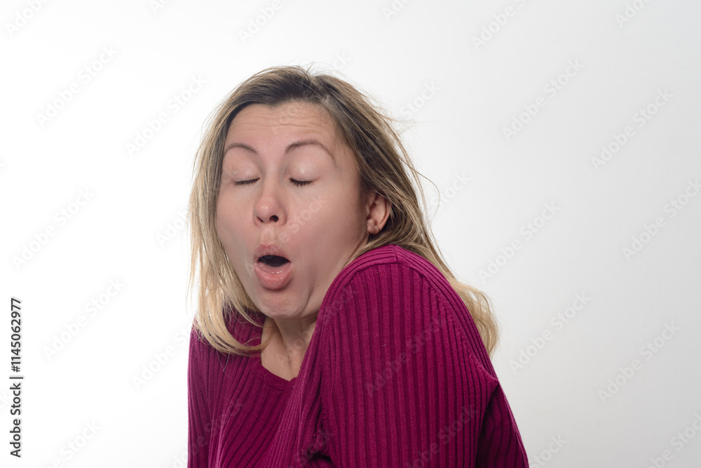 A woman with shoulder-length blond hair, wearing a maroon ribbed sweater, is shown against a white background with her mouth open and eyes closed. A woman with shoulder-length blond hair, wearing a maroon ribbed sweater, is shown against a white background with her mouth open and eyes closed.
