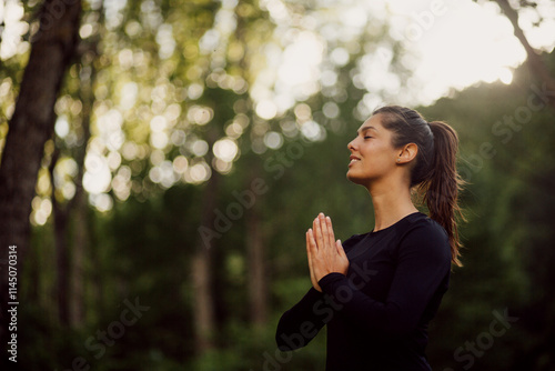 Calm woman practicing yoga in a park