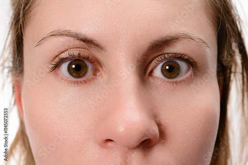 Close-up view of a woman's face with wide, surprised eyes and raised eyebrows, conveying a sense of astonishment or shock.