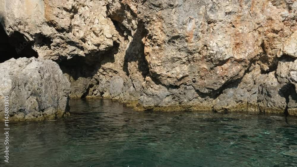 Landscape showing the Mediterranean sea waves impacting against the rocks, from inside a sea cave in the coastal town of Sa Rapita, Majorca, Spain. . High quality 4k footage Landscape showing the Mediterranean sea waves impacting against the rocks, from inside a sea cave in the coastal town of Sa Rapita, Majorca, Spain. . High quality 4k footage