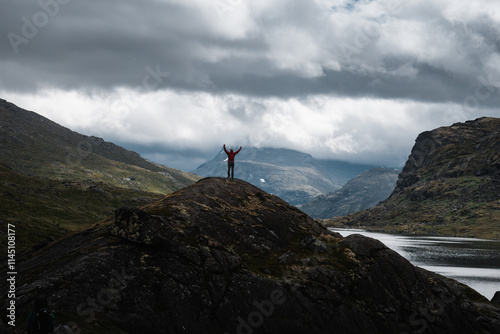 Hiker Celebrating on a Mountain Top with River in Norway photo