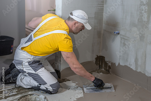 A worker applies a liquid membrane on the bathroom floor. Foolproof waterproofing under a tile bathroom. photo