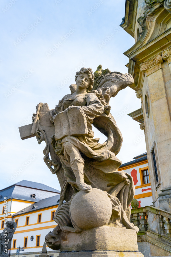 Obraz premium A detailed view of a Baroque statue, showcasing intricate design, located at the Kuks hospital complex in Czechia. The statue adds historical value to the beautiful architecture surrounding it.