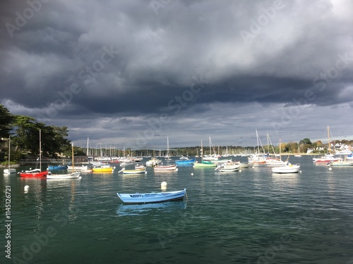 Vue sur les barques et les bateaux du port de Sainte-Marine (Finistère sud, Bretagne), par temps calme, ciel orageux et lourds nuages gris foncé photo