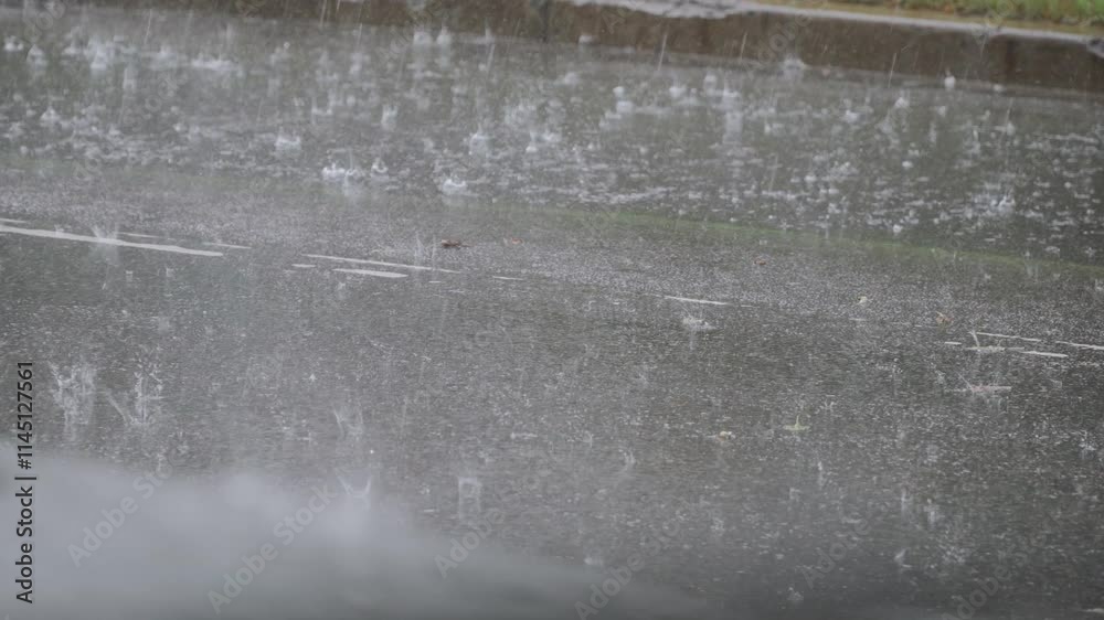 Surface of asphalt road covered with water with traces of falling raindrops during heavy rain in city. Background video of bad weather and flowing streams of water on city street.