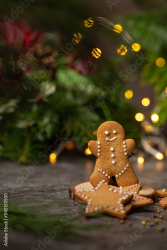 Gingerbread cookies of different shapes, gingermen, christmas tree, stars, reindeer with christmas lights on dark background  photo