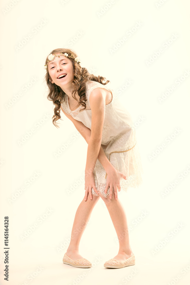 Cheerful young girl smiling and bending forward in a white dress Cheerful young girl smiling and bending forward in a white dress