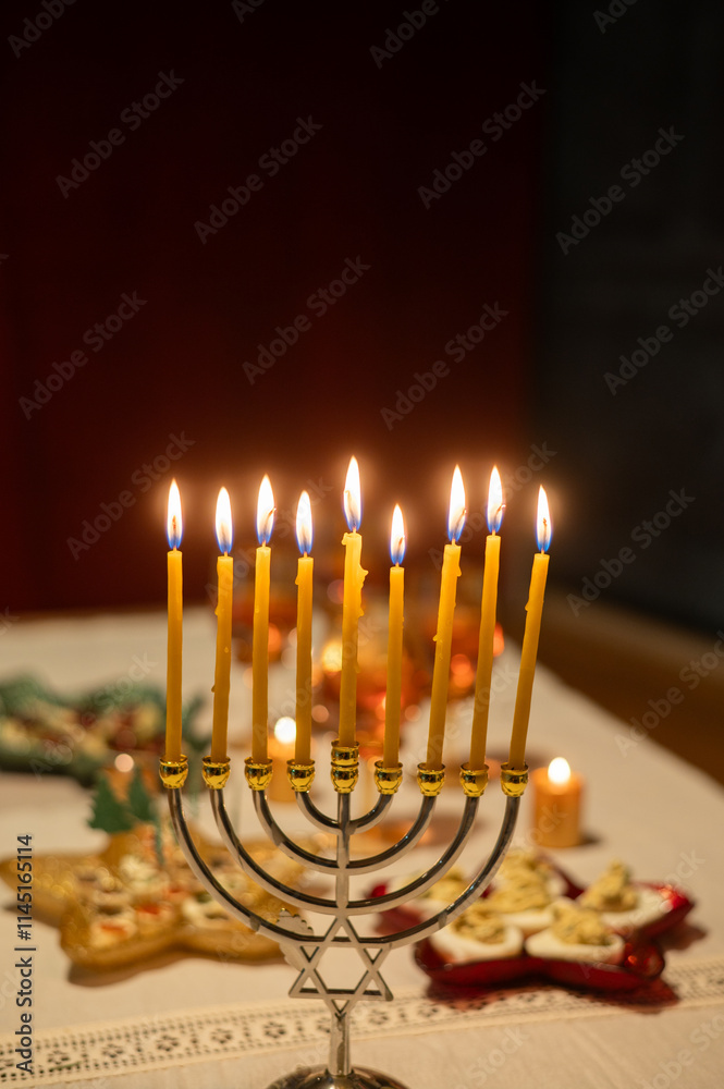 Fototapeta premium candles burning in menorah on festive table for Hanukkah