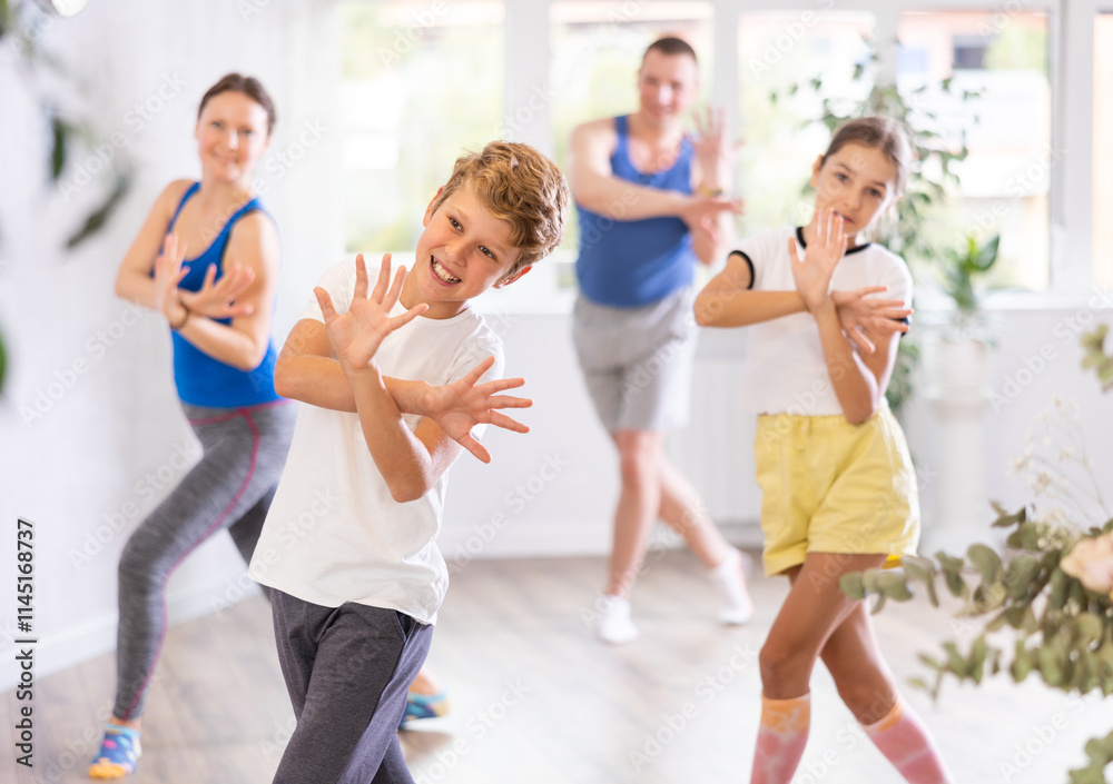 Fototapeta premium Parents together with their children learn how to dance salsa or boogie-woogie in a dance class