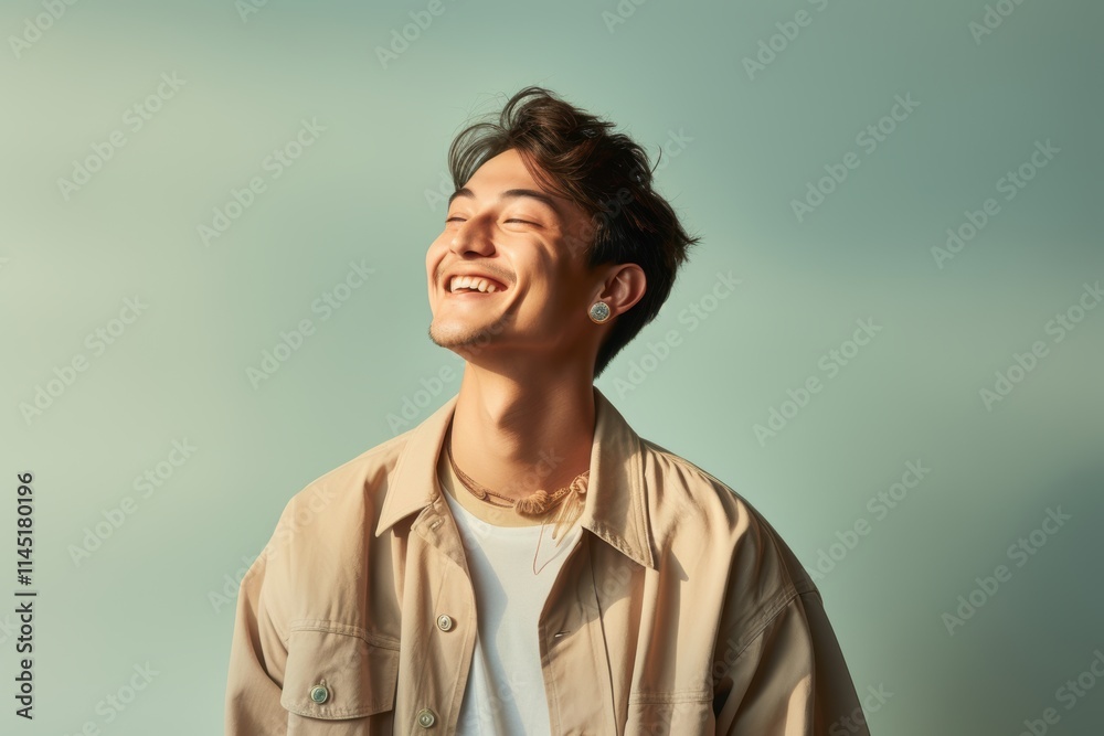 A man is smiling and wearing a tan jacket