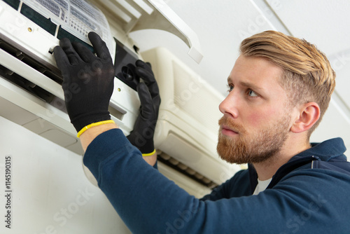 professional electrician fixing the heavy air conditioner unit