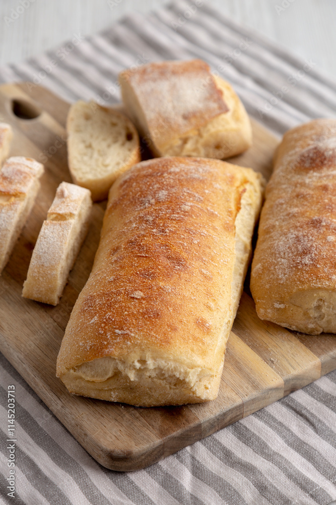 Homemade Sliced Ciabatta Bread on a wooden board, side view. Homemade Sliced Ciabatta Bread on a wooden board, side view.