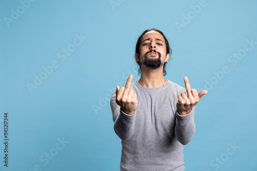 Obraz na płótnie Offensive guy showing the middle finger in front of the camera and being impolite, acting aggressive and furious with an obscene sign