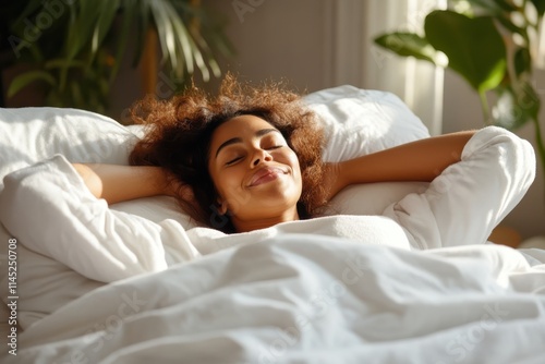 A woman smiles contently as she lies in bed surrounded by lush green indoor plants, enjoying the morning light with her hands resting behind her head. photo