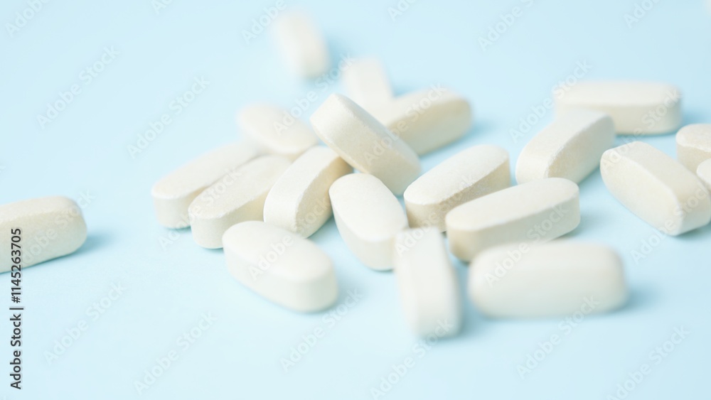 A bunch of white pills tablets on light blue background,. High quality photo A bunch of white pills tablets on light blue background,. High quality photo