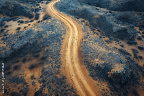 Winding dirt road through rugged terrain offers stunning views at sunset