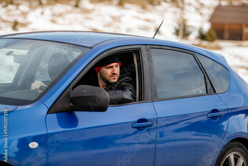 Another busy day. Handsome young man looking away while driving a status car photo