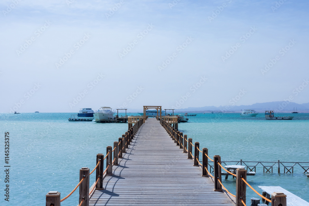 Obraz premium Serene seascape with wooden pier and boats on turquoise water
