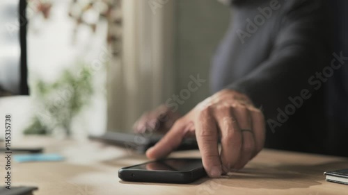 person receiving mail message on smart phone mobile,male employee working at the desk receives email notification on the smartphone