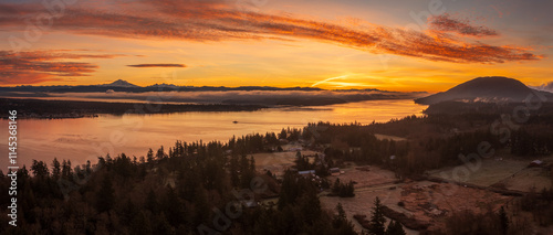 Aerial view of a dramatic sunrise over Lummi island and Hale Passage with Mt. Baker in the background. A ferryboat can be seen crossing the pass across to Gooseberry Point on the mainland. photo