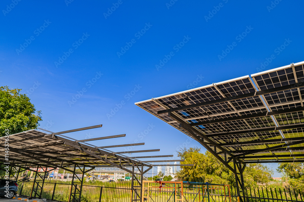Obraz premium Solar panel carport providing shade for parked vehicles on a sunny day. Renewable energy infrastructure combining solar power generation and parking solutions for sustainable development.