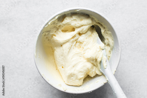 overhead view of smooth buttercream in a mixing bowl,Top view of cream buttercream in a white mixing bowl, silky smooth american buttercream in a ceramic bowl