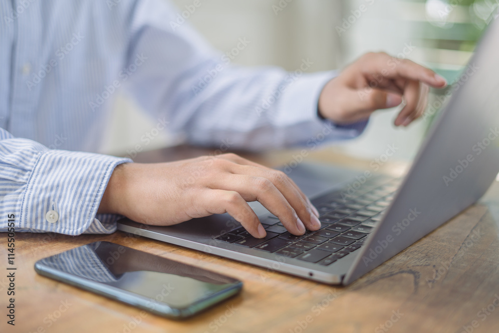 Close up of businessman working with laptop computer on table at office. Business man hands typing on laptop, online working, surfing the internet at workplace Close up of businessman working with laptop computer on table at office. Business man hands typing on laptop, online working, surfing the internet at workplace