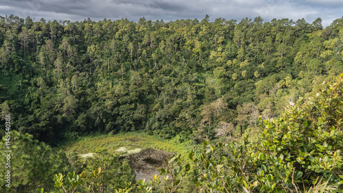 The crater of an extinct volcano. At the bottom you can see a lake surrounded by thickets of lush green rainforest. Blue sky, clouds. Mauritius. Trou-aux-Cerfs. Murr's Volcano photo