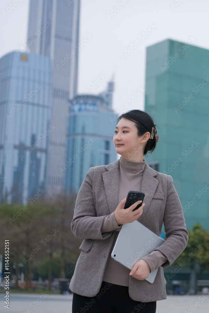Confident Businesswoman in Urban Setting with Smartphone and Tablet Confident Businesswoman in Urban Setting with Smartphone and Tablet