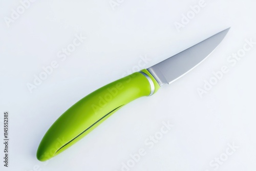 A lime green handled paring knife rests on white photo